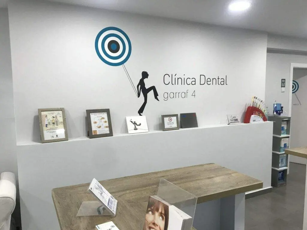 Recepción de la Clínica Dental Garraf 4 con el logotipo de la clínica en la pared