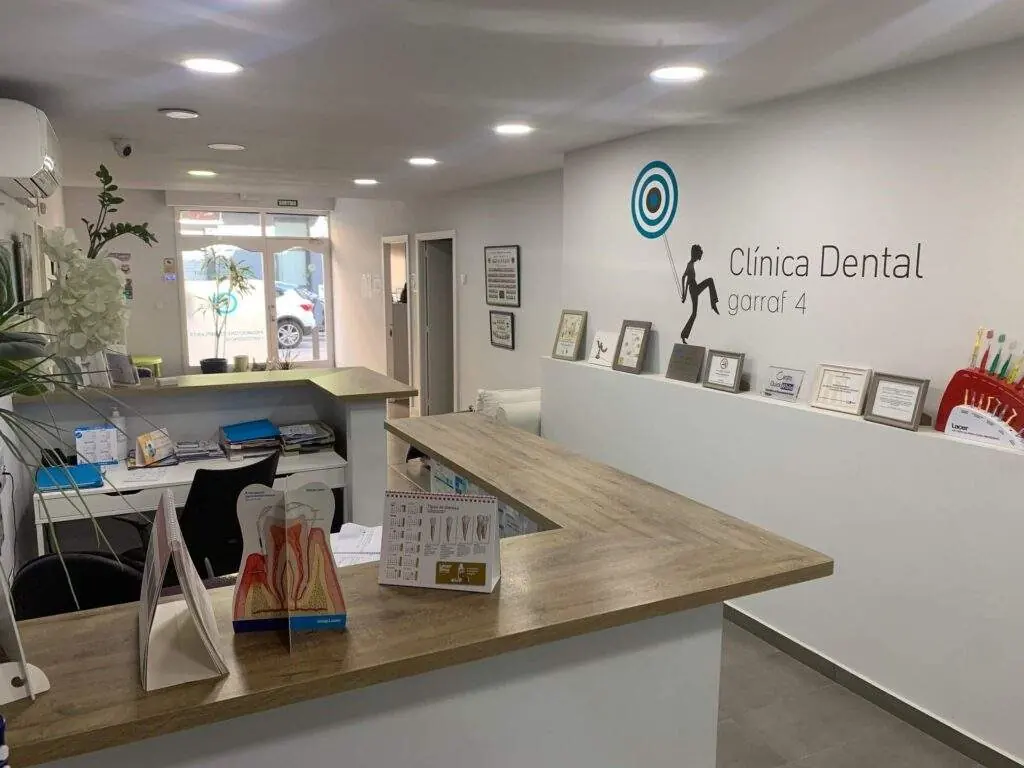 Recepción de Clínica Dental Garraf 4 en Cornellà, con el logotipo de la clínica en la pared
