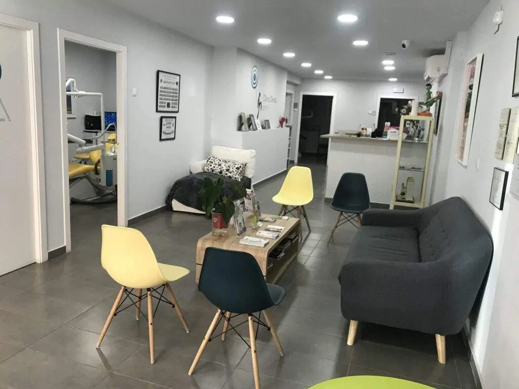 Sala de espera de Clínica Dental Garraf 4 con sofá y sillas de colores